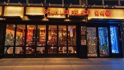 Night view of the Shun Lee Palace storefront on East 55th Street: the glowing sign “SHUN LEE PALACE 扬州楼” above glass doors into the warmly lit dining room.